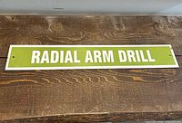 Full view of green metal sign with white text