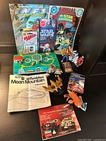 Group shot showing comics, Star Wars figures, playset board, manuals, pin, mini book and toy pieces