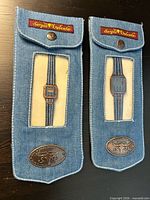 Front view of both denim-cased watches in original pouches