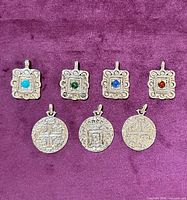 Front view of all seven pendants on purple background