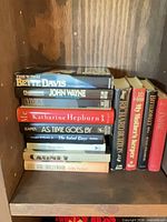 Stacked view of several biographies showing spines such as This ’n That, John Wayne, Vivien, Katharine Hepburn, As Time Goes By plus adjacent titles Richard Burton and My Mother’s Keeper