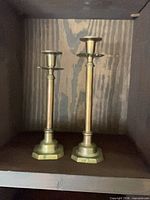 Front view of both brass candlesticks standing upright