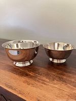 Front view of both polished silver-plate bowls