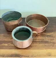 Three copper vessels displayed