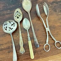 All five utensils laid out side by side on wood surface