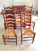 front angled view of all five chairs showing ladder backs and rush seats