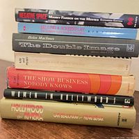 Seven books stacked showing spines