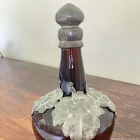 Full view of decanter front showing amber glass body and pewter grapeleaf overlay