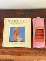 Book and model car side by side on table