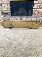 Full view of engraved brass panel standing in front of fireplace