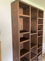 Full view of tall dark wood bookshelf against wall