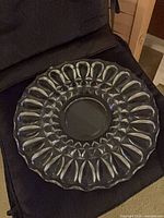 Overhead view of entire clear glass platter showing teardrop starburst design and scalloped rim