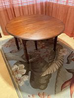 Round wooden dining table on rug