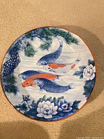 Top view showing koi fish, lotus, pine design and orange rim
