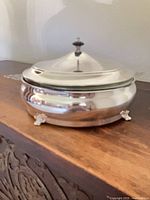 casserole assembled with lid on, showing feet and reflective finish
