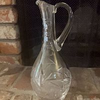 Full view of cut crystal wine carafe on hearth