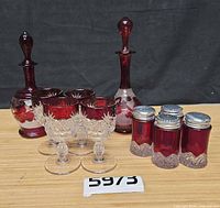 Group shot: two cranberry bottles with stoppers, four cut-to-clear cups, four ruby flash shakers