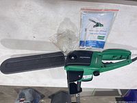 Left side view showing full chain saw with bar cover and manual