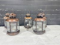 Front view of five copper tone lanterns
