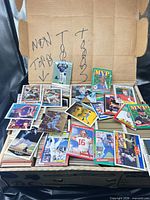 Open box showing numerous trading cards spread on top of rows