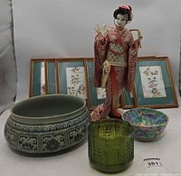 Group shot showing all items: geisha doll, six framed prints, planter, floral bowl, green jar