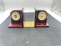Front view of both wood bookends showing clock and barometer faces