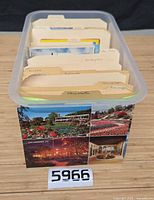 Plastic file box filled with tab-separated postcards, exterior collage postcard on front