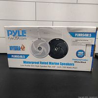 Front of sealed retail box showing speakers and specifications