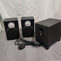 Overall view of subwoofer, two satellite speakers, and control pod