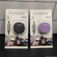 Front view of two boxed Bluetooth AUX receivers