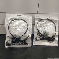 Two factory-packaged Bluetooth neckband headsets front view