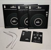 Front view of three retail TapMedID tag packs, two clear loops, two loose tags