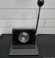 Front view of tabletop lever die cutter showing base, die opening and handle