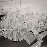 Pile of clear plastic pop-top containers showing size and quantity