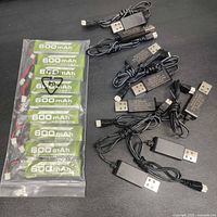 Bag of nine green 600 mAh LiHV batteries and eight black USB charger cables