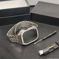 Stainless steel link bracelet attached to watch adapter with link sizing tool and screwdriver