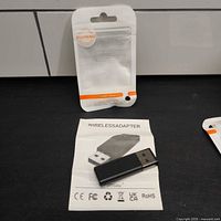 USB wireless adapter on instruction sheet beside ELUTENG packaging