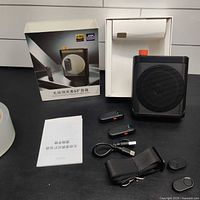 Full lot showing speaker, two microphones, strap, cable, mounts, manual and box