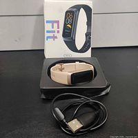 Complete lot showing tracker, charging cable, box