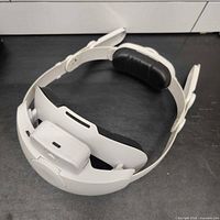 Overall view of white head strap showing integrated battery pack and black rear cushion