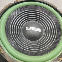 Front view of MEI subwoofer showing cone, surround and logo