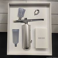 full kit in tray: airbrush unit, extra cup, nozzle cap, accessory box