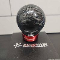 Top view of spherical carbon fiber shift knob on branded box