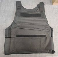 Front view of black nylon security vest showing Velcro panels and wrap-around closure