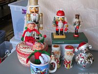 Group shot showing nutcrackers, elves, Santa candle holders, serving bowl, novelty mug, silver bear music box