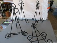 Four black wrought iron easels on table