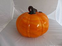 Full view of orange glass pumpkin with stem