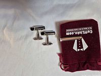 Cufflinks, tie bar and branded pouch overview