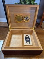 Open humidor showing cedar interior, hygrometer, humidifier, divider, cutter