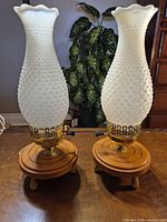 Full view of both lamps showing shades, brass collars, wooden bases